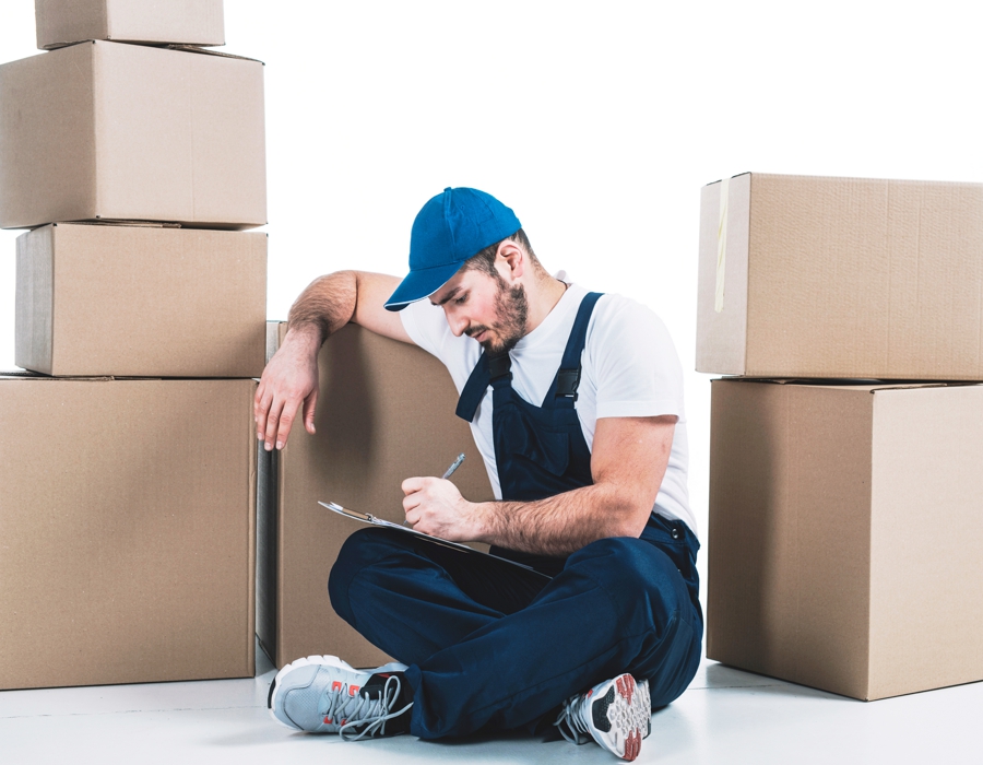 déménageur assis devant des cartons de déménagement